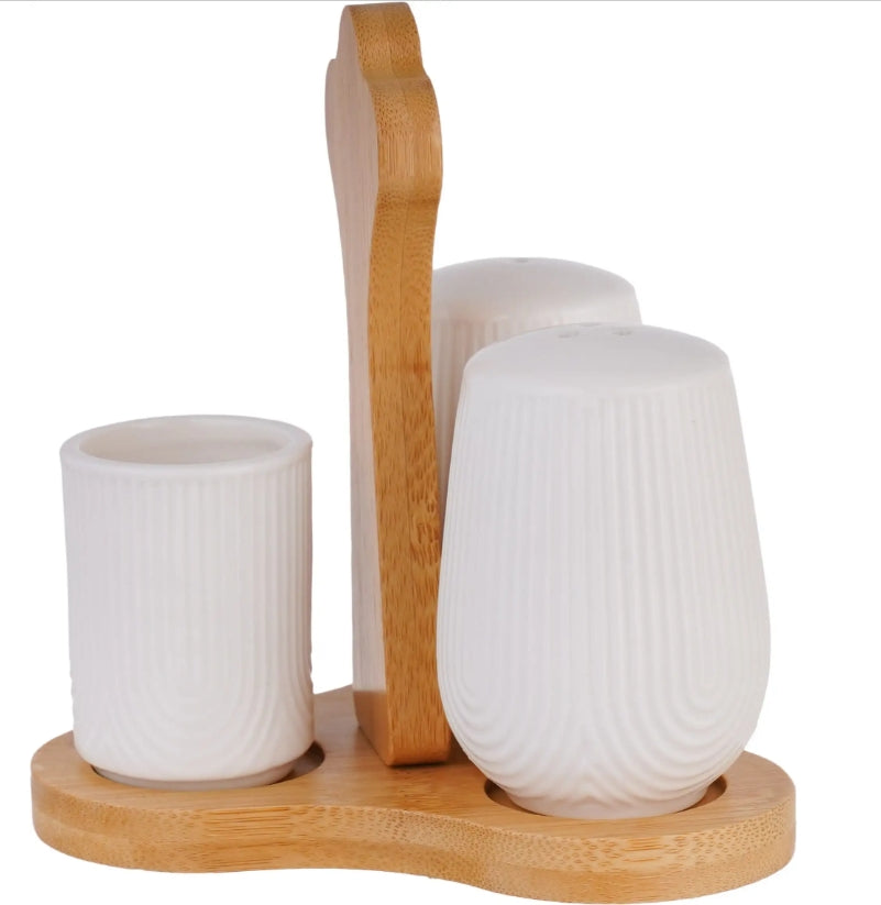 ZINNIA wooden spice holder with compartments for salt, pepper, and vinegar containers on a kitchen countertop.
