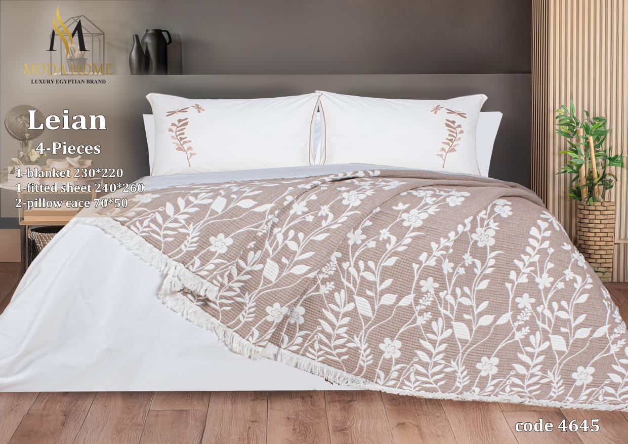 MODA HOME Layan Ghosn 4-piece coverlet set with decorative bedding in neutral tones, displayed on a bed.